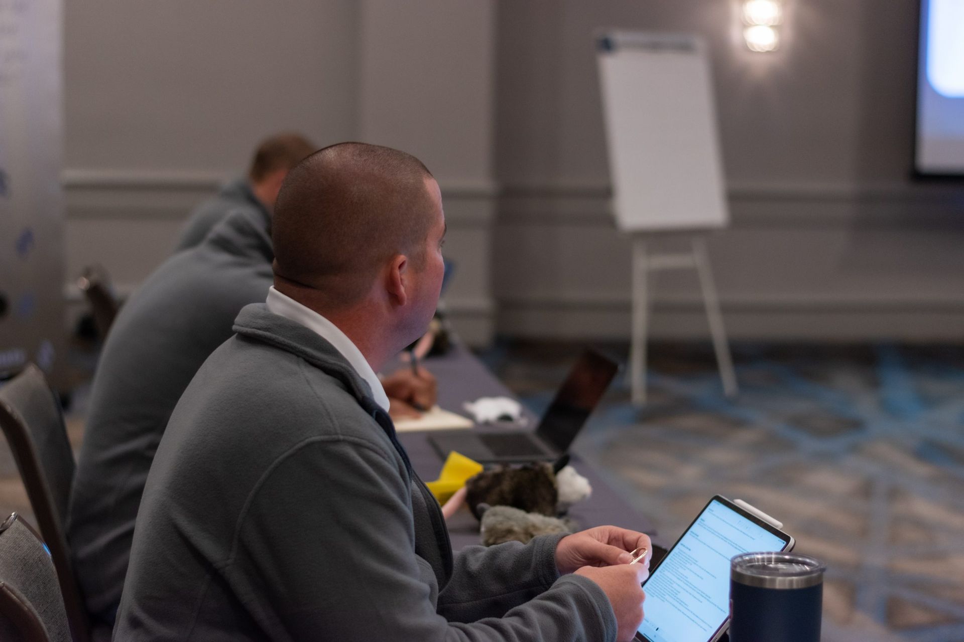 A man is sitting at a table using a laptop computer.