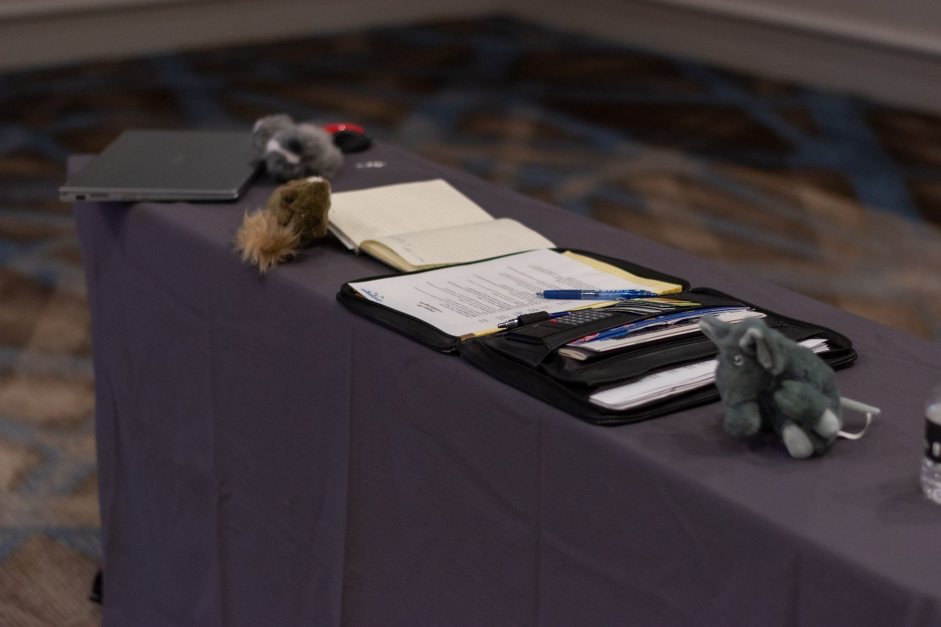 A table with a notebook and a stuffed elephant on it