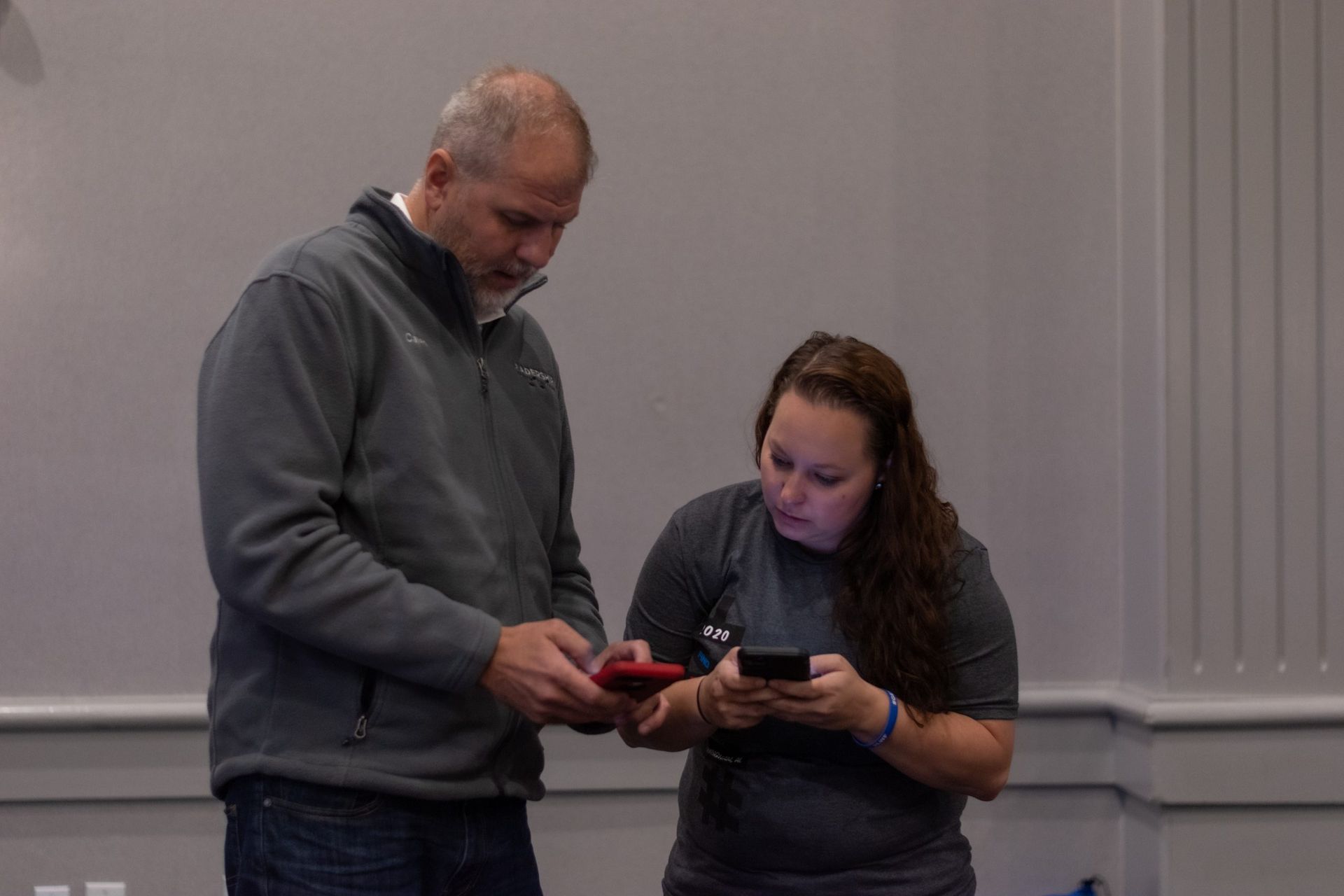 A man and a woman are looking at a cell phone.
