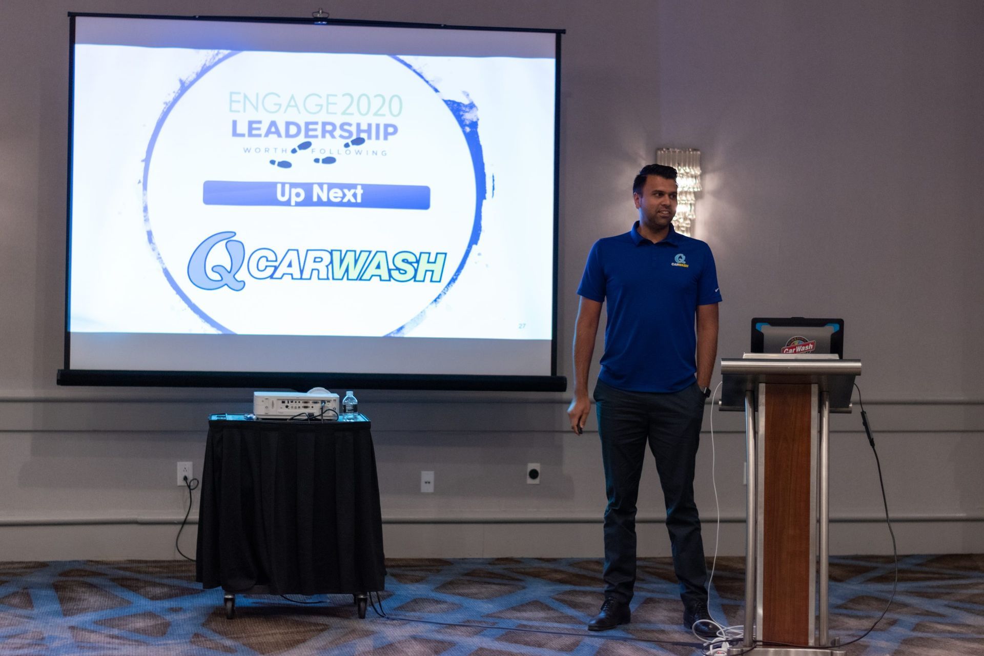 A man is giving a presentation in front of a large screen.