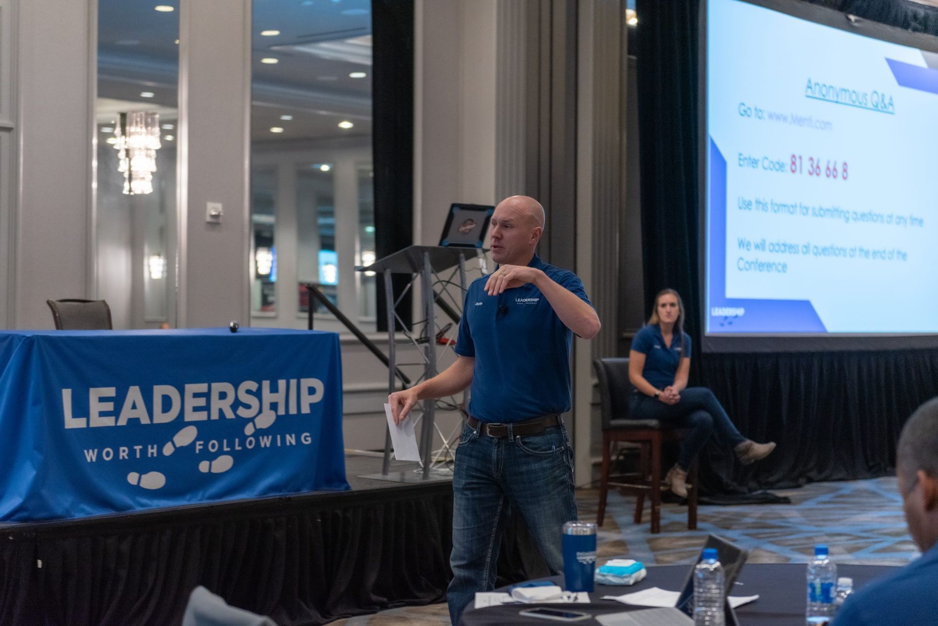 A man is standing on a stage giving a presentation.