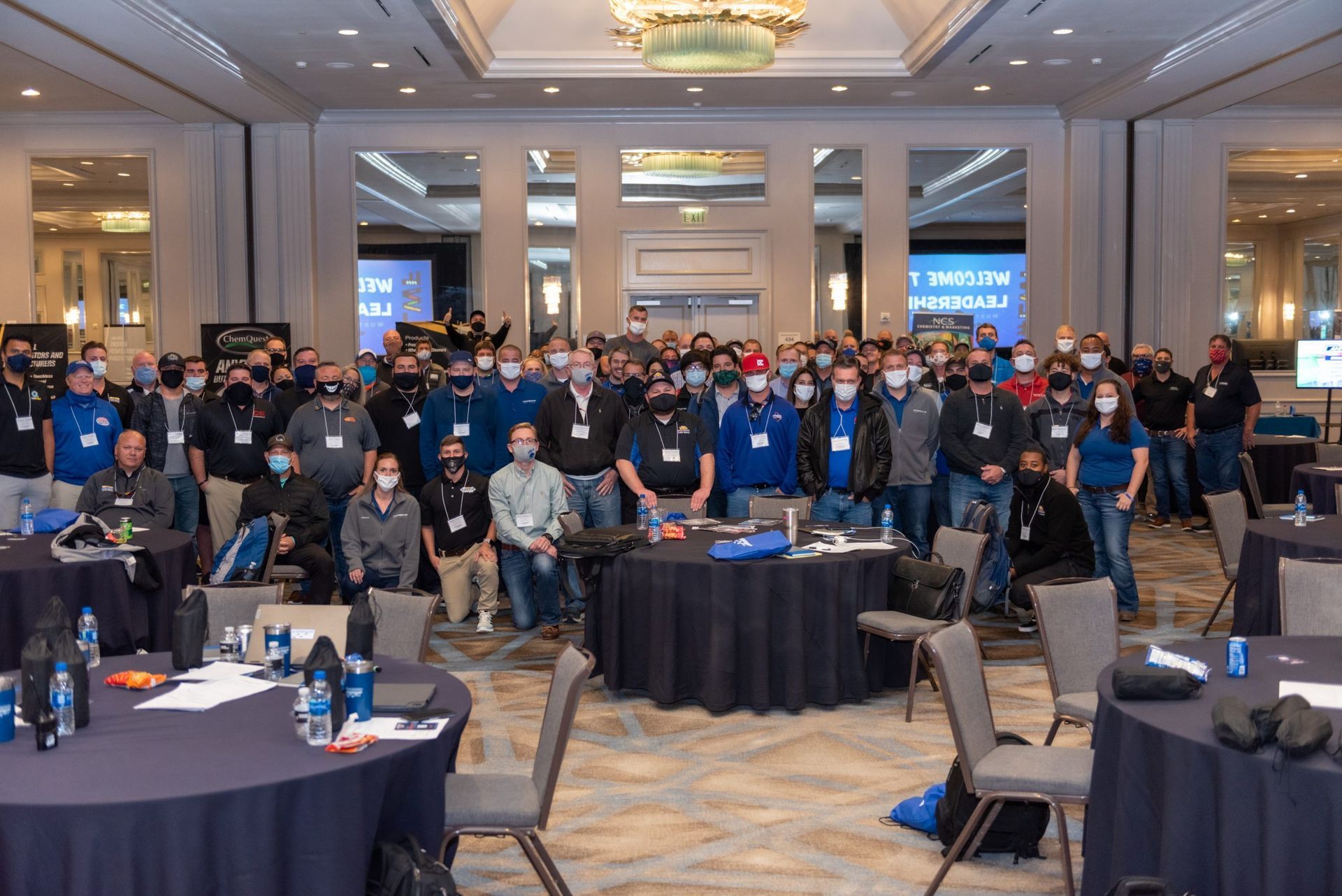 A large group of people are posing for a picture in a conference room.