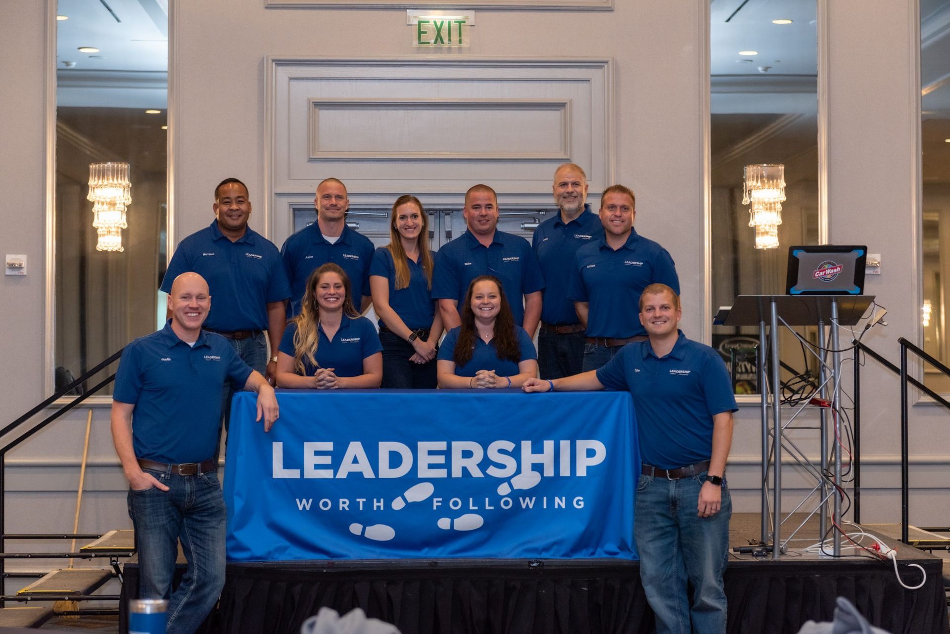 A group of people standing in front of a leadership banner