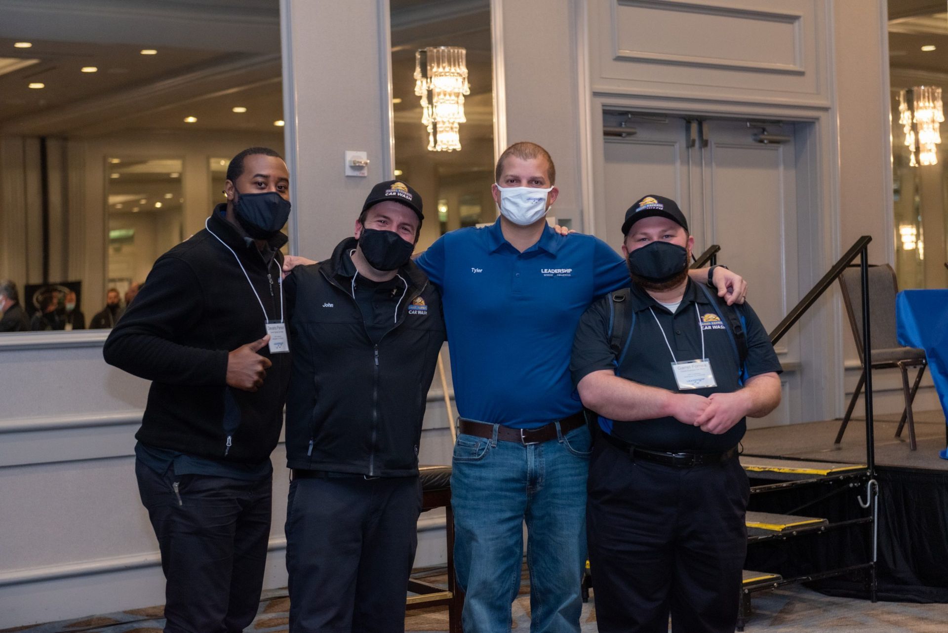 A group of men wearing face masks are posing for a picture.