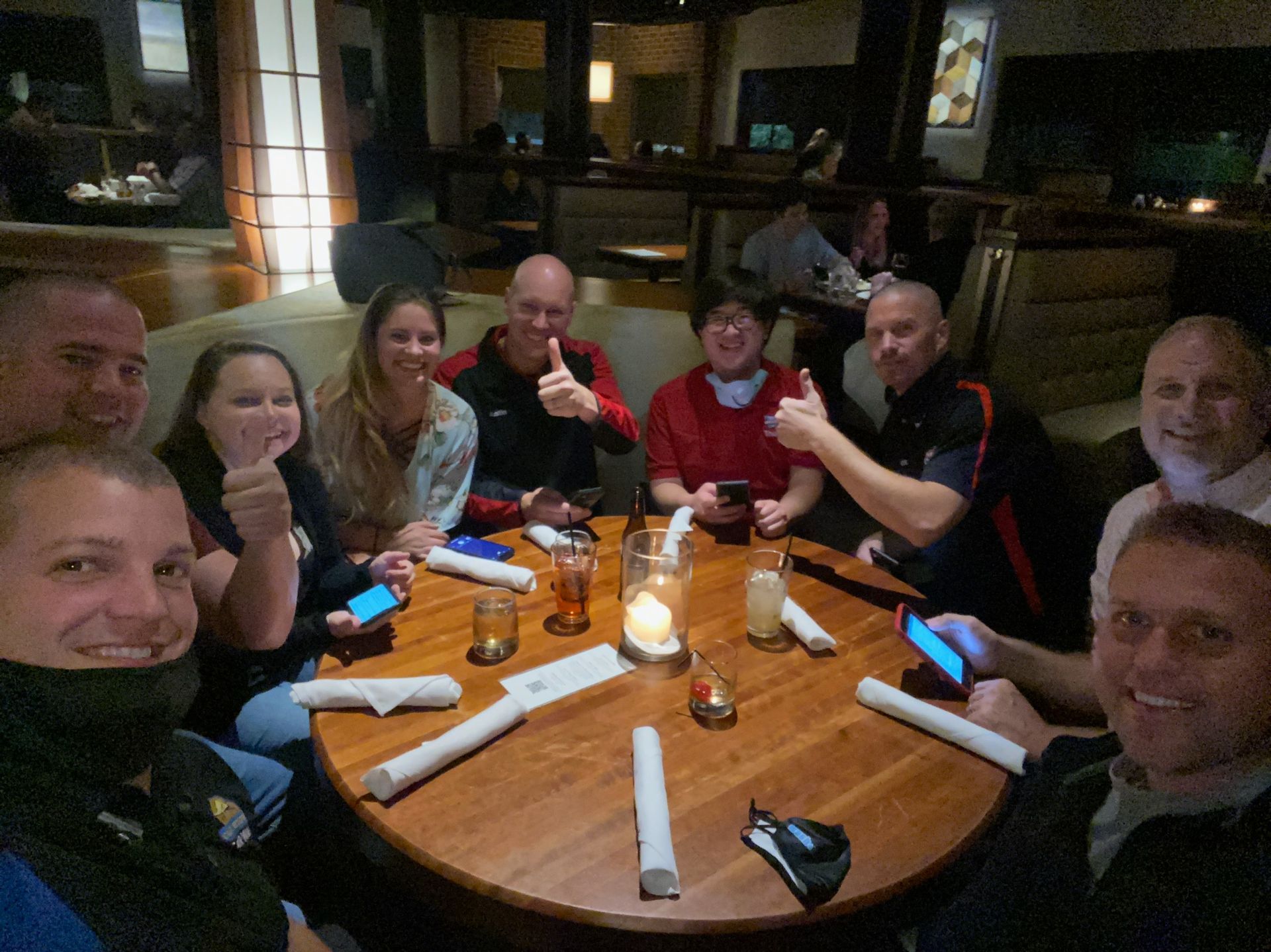 A group of people are sitting around a table in a restaurant.