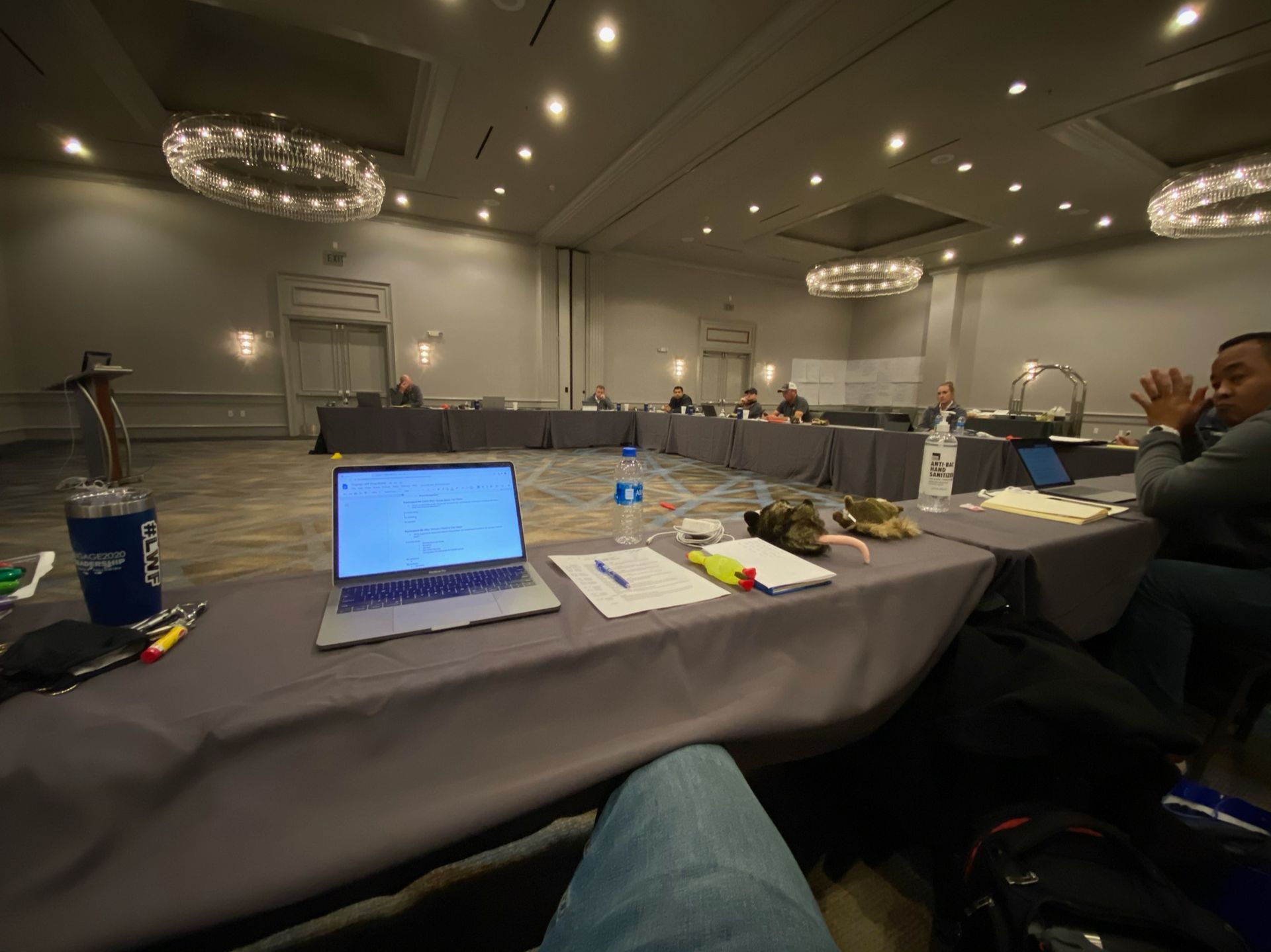 A laptop is sitting on a table in a conference room.