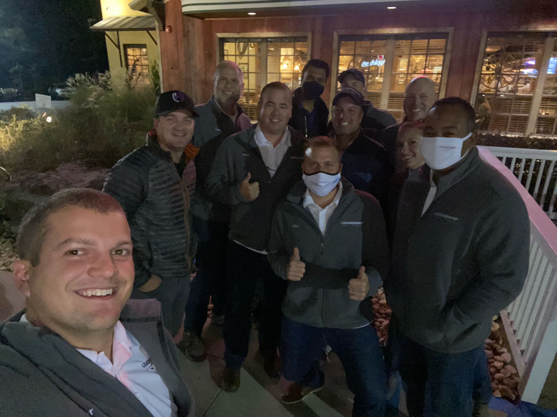 A group of people wearing face masks are posing for a picture.