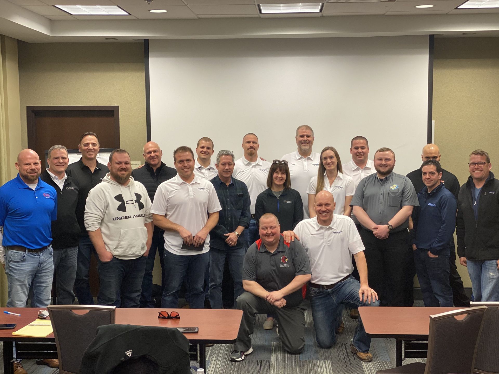 A group of people are posing for a picture in a conference room.