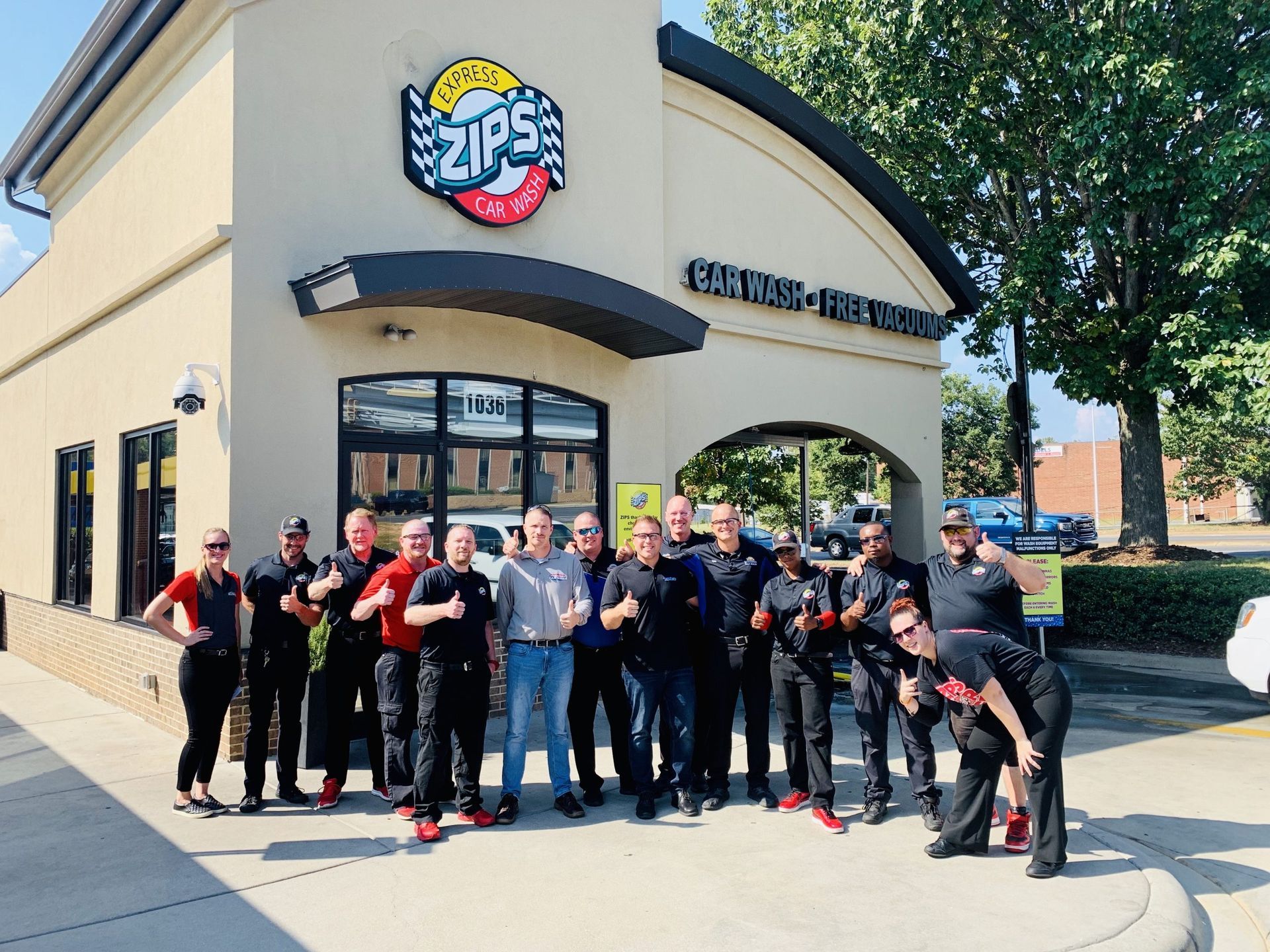 A group of people standing in front of a zips restaurant