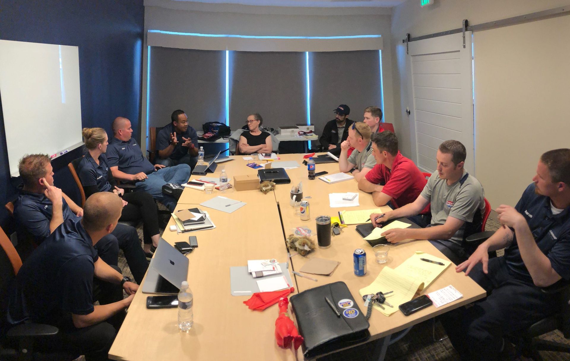 A group of people are sitting around a long table in a conference room.