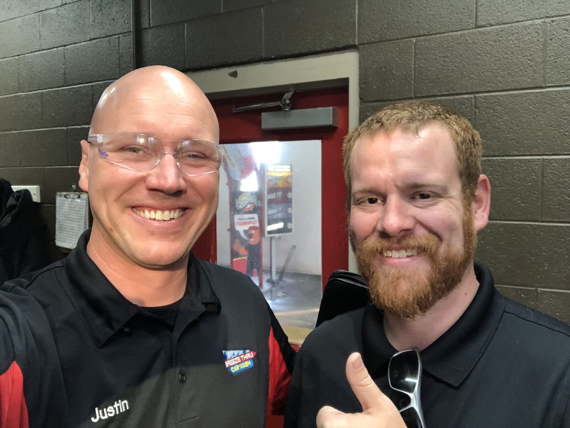 Two men are posing for a picture and one has justin written on his shirt