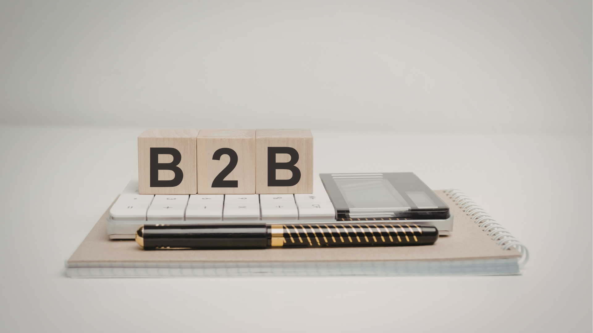 Man typing on keyboard, coding on dual computer monitors, at a desk in a dimly lit room.