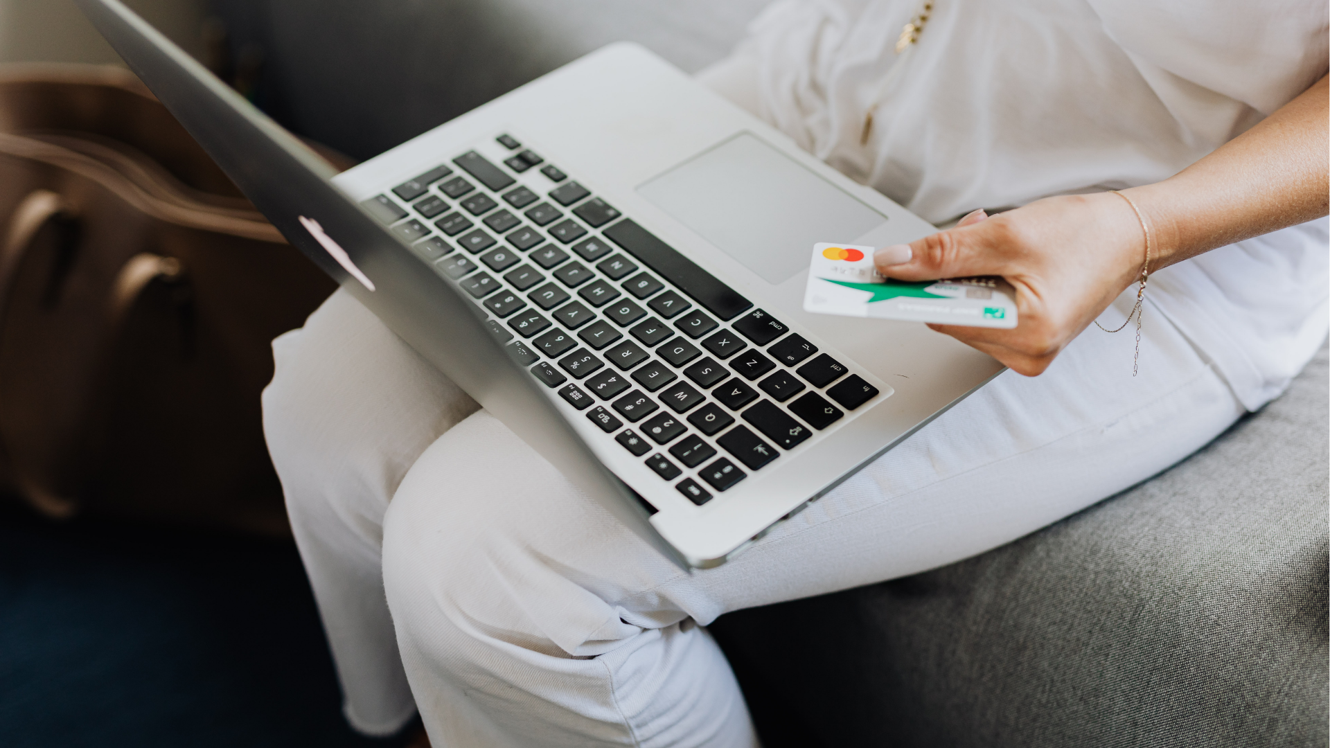 Man typing on keyboard, coding on dual computer monitors, at a desk in a dimly lit room.