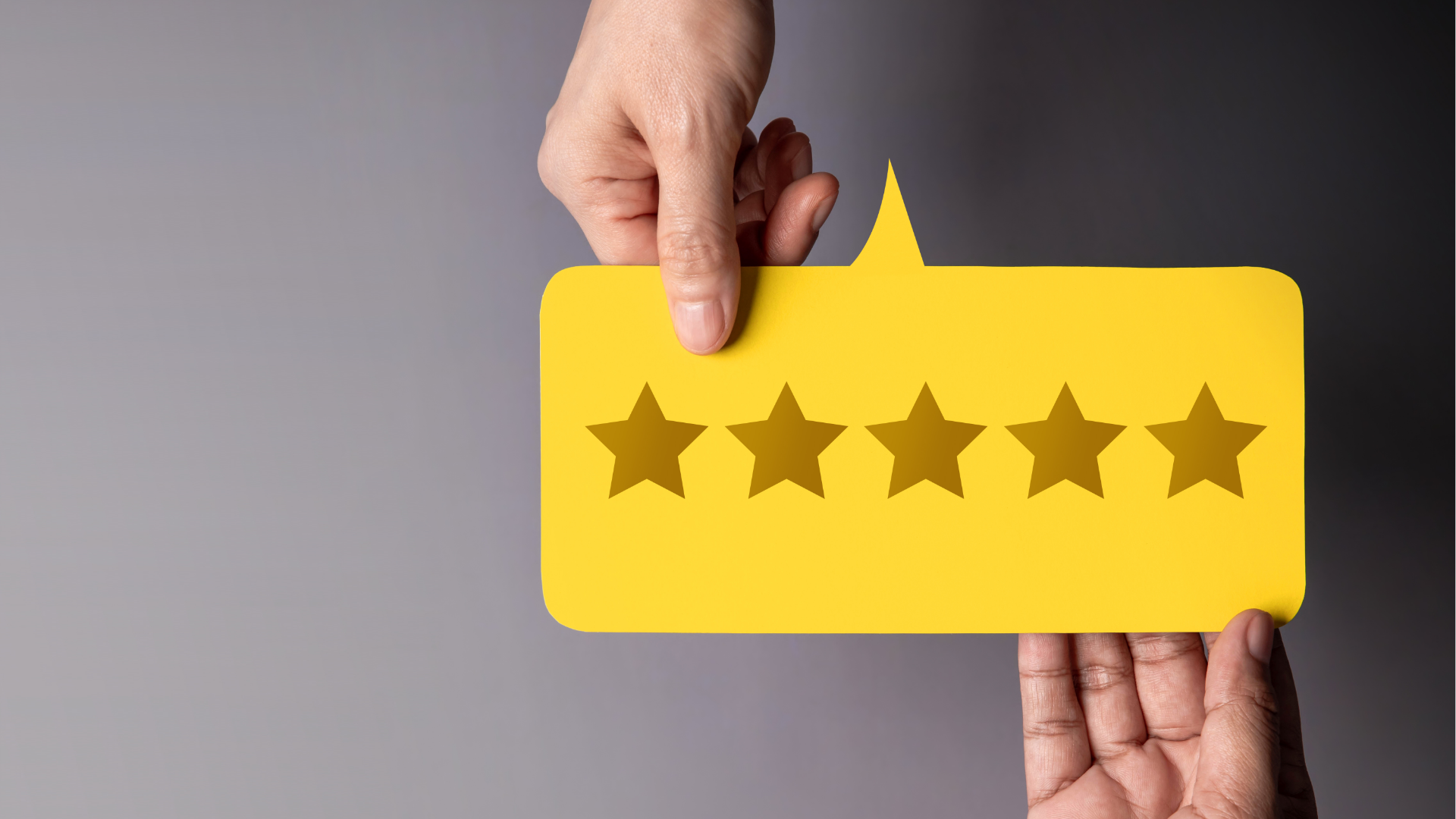 People at a table looking at laptops. They are smiling and working in a modern office.