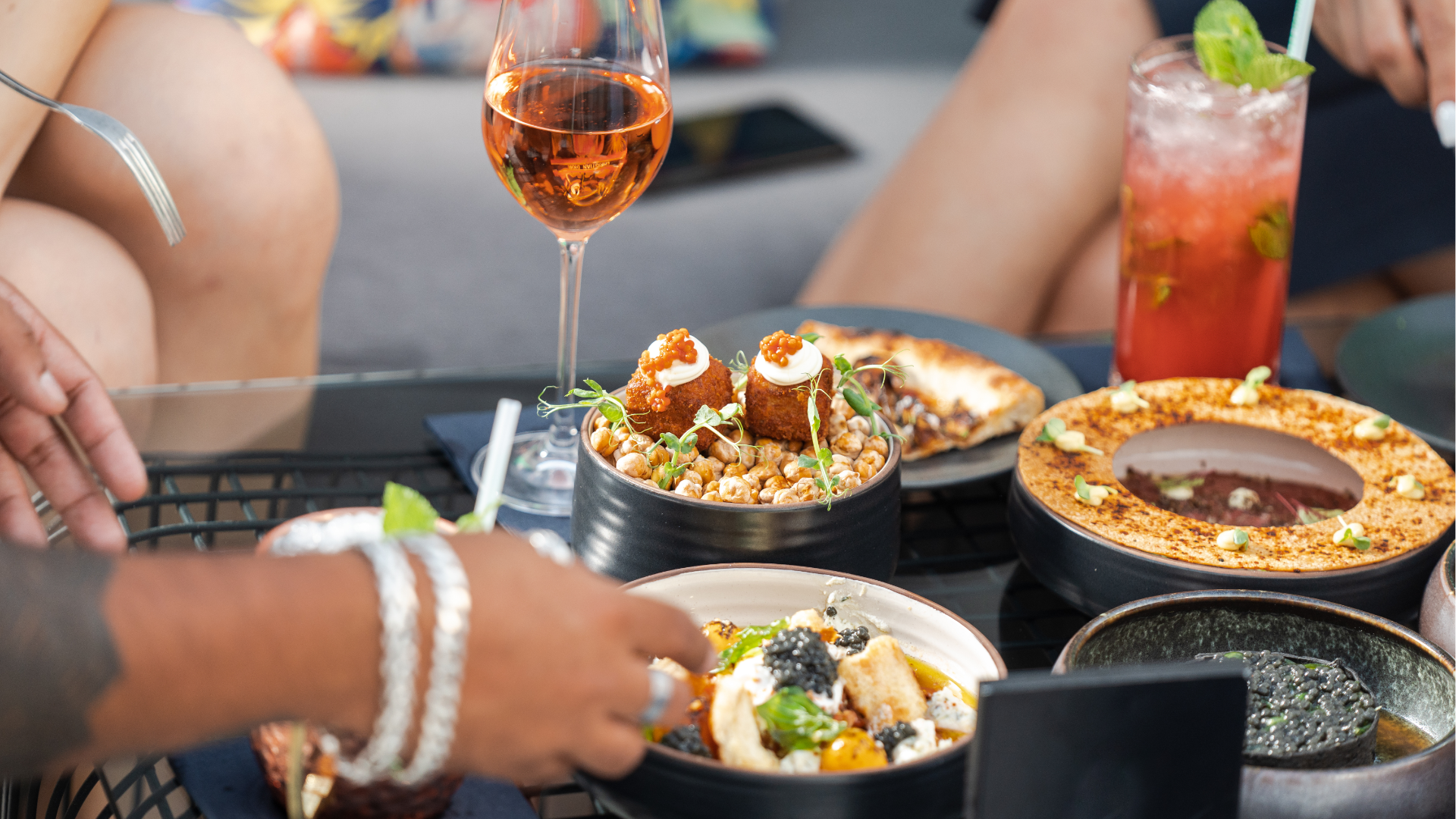 Man typing on keyboard, coding on dual computer monitors, at a desk in a dimly lit room.