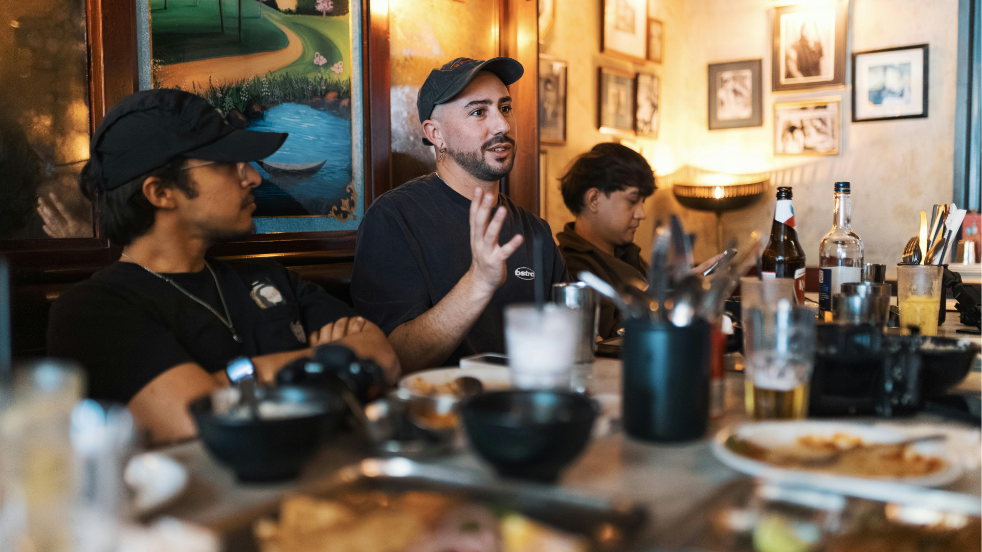 Person typing on laptop, viewing financial charts and pie chart. Phone rests beside the laptop on wooden table.