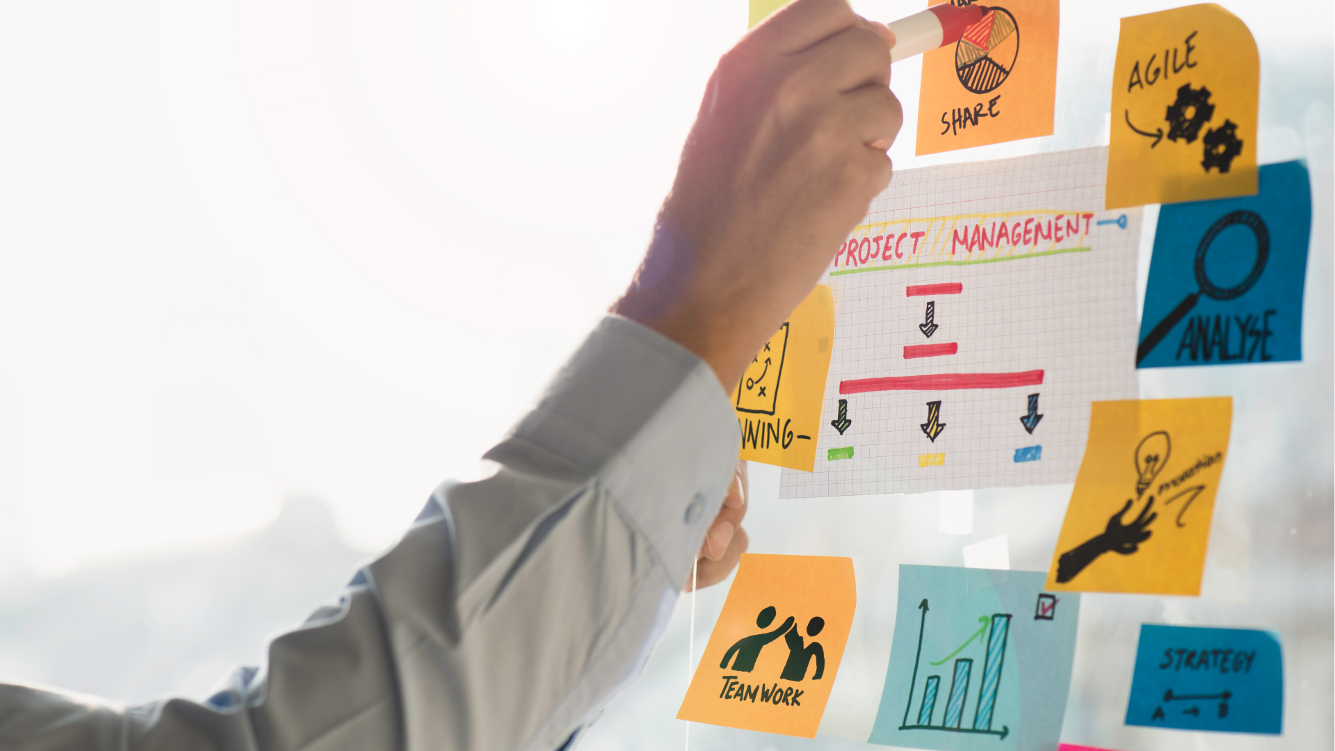 People at a table looking at laptops. They are smiling and working in a modern office.