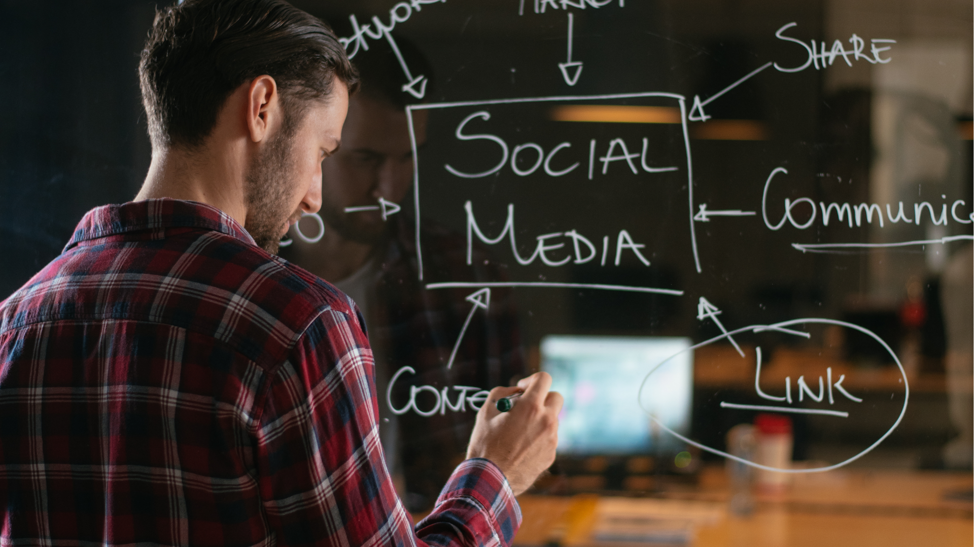 People at a table looking at laptops. They are smiling and working in a modern office.