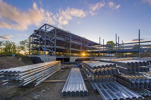 a large building under construction with a lot of steel beams stacked on top of each other .