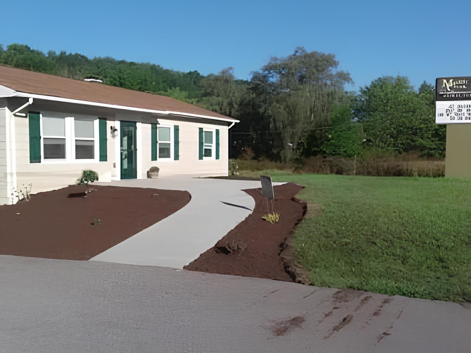 a white house with green shutters and a sign that says max