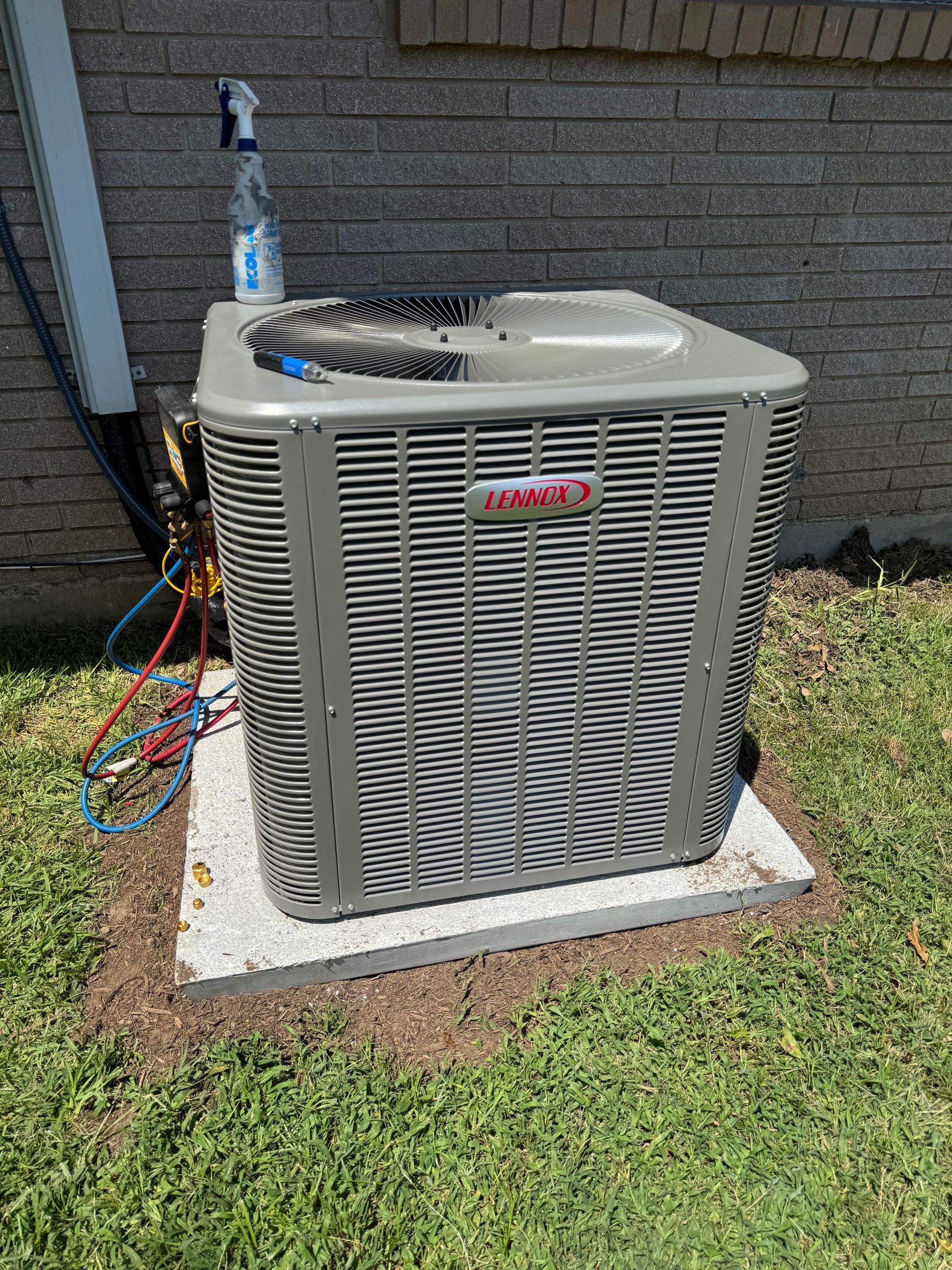 AC unit outside a home, on a concrete base, with landscaping.
