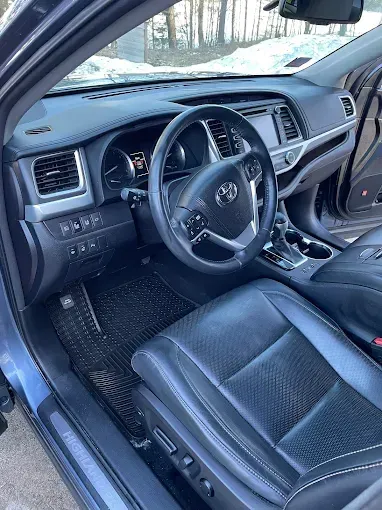 The interior of a car with a steering wheel and seats.