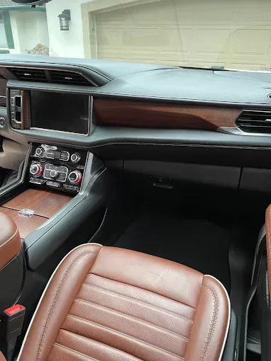 The interior of a car with brown leather seats and a dashboard.
