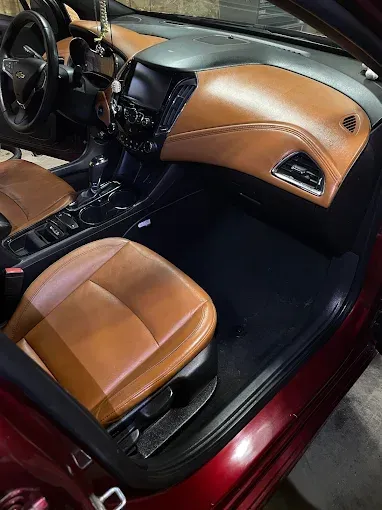 The interior of a red car with brown leather seats