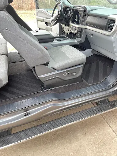 The inside of a car with the door open and the seats up.