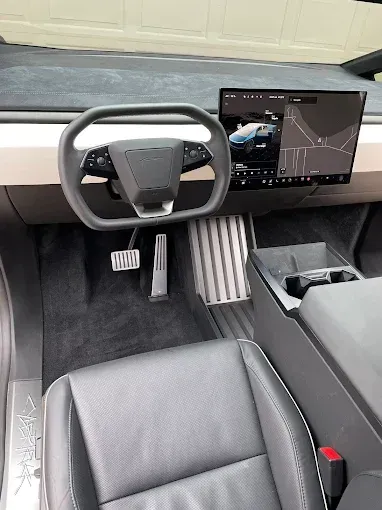 The interior of a tesla model s with a steering wheel and dashboard.
