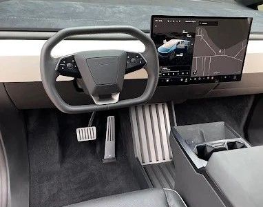The interior of a tesla model s with a steering wheel and dashboard.