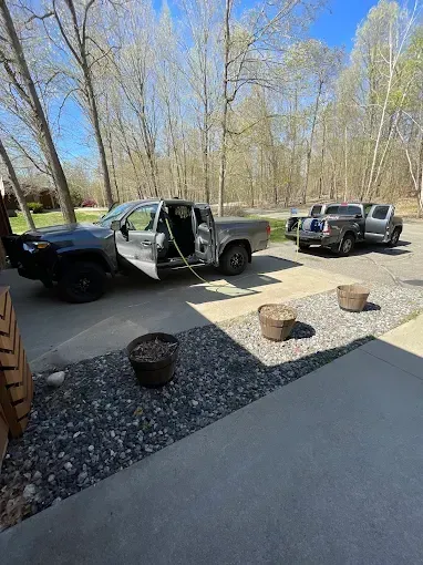 A truck is parked in a driveway with the door open.