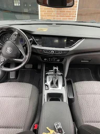 The interior of a car with a steering wheel and a dashboard.