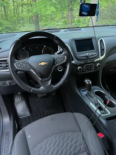 The interior of a chevrolet equinox with a steering wheel and dashboard.