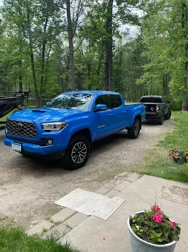 A blue toyota tacoma truck is parked in a driveway.