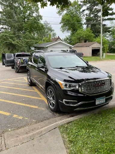 A black gmc acadia is parked in a parking lot.