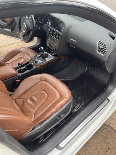 The interior of a white car with brown leather seats.