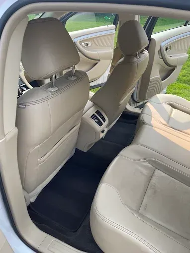 The inside of a white car with tan leather seats.
