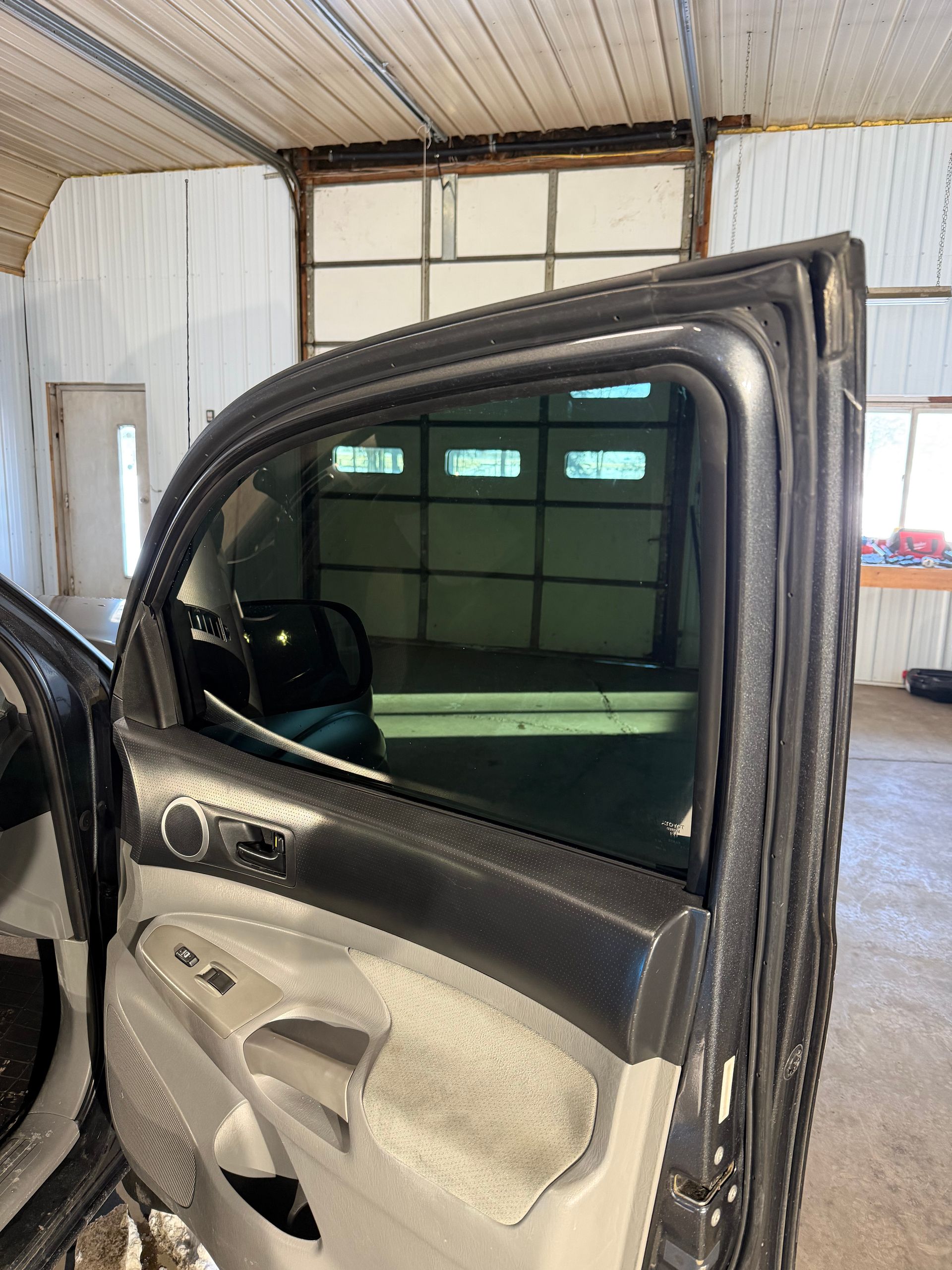 White Tesla SUV parked in an outdoor lot on a rainy day; black wheels, tinted windows.