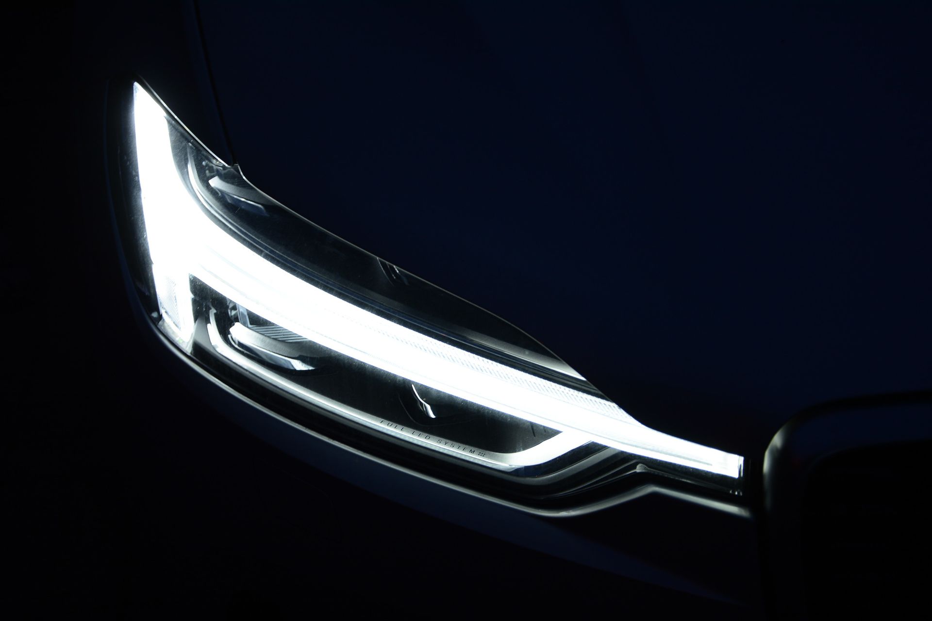 A person is cleaning a red car with a green cloth.