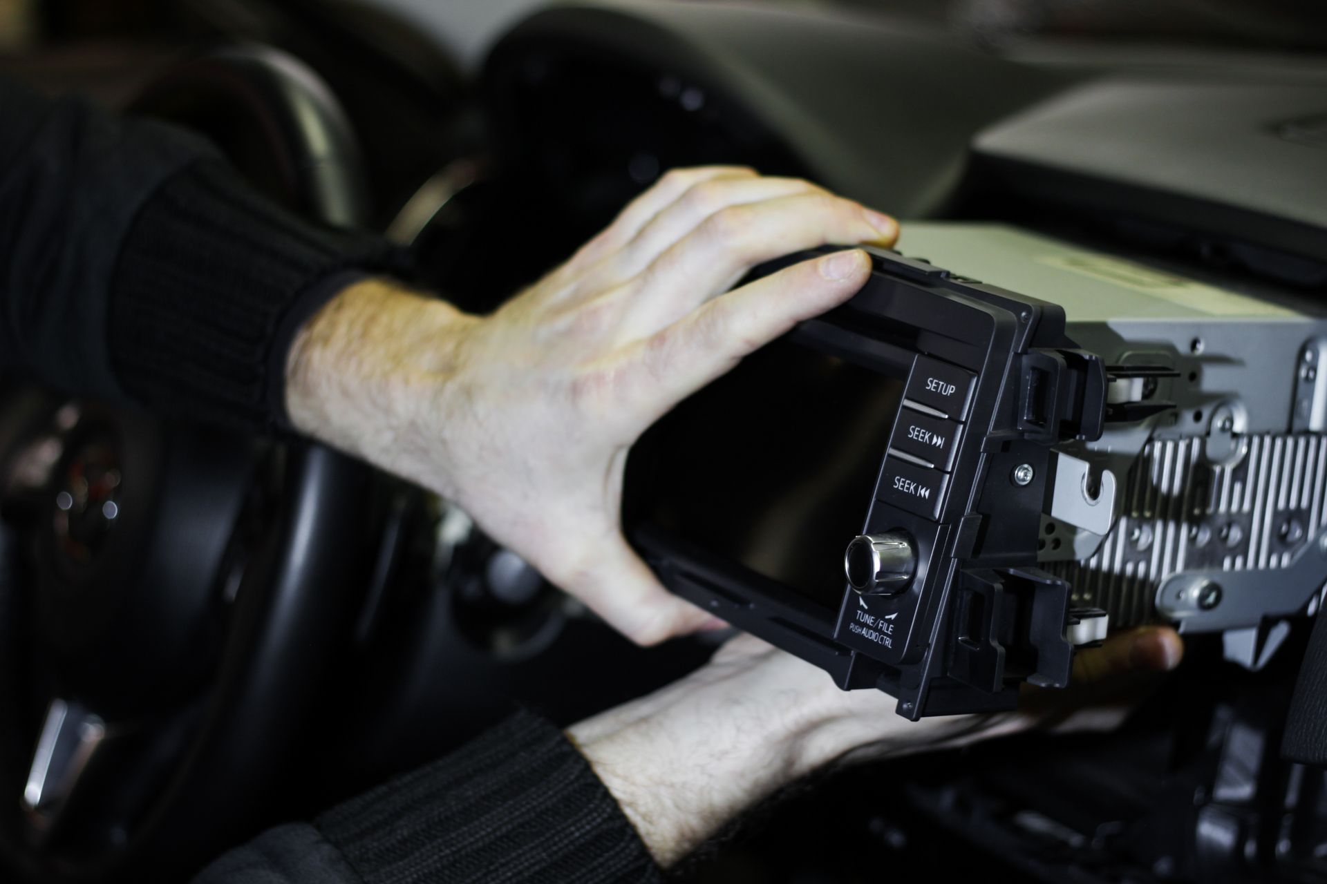 A person is cleaning a red car with a green cloth.
