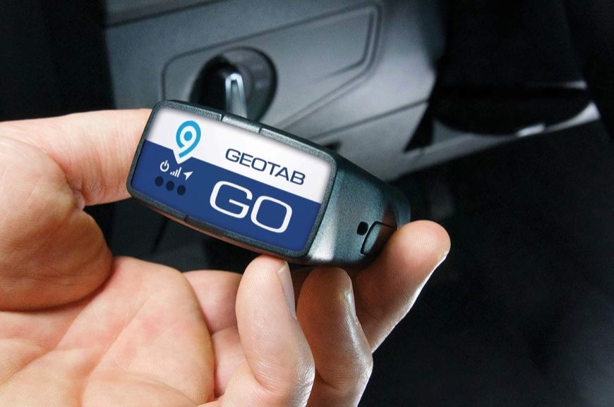 A person is holding a geotab go device in their hand