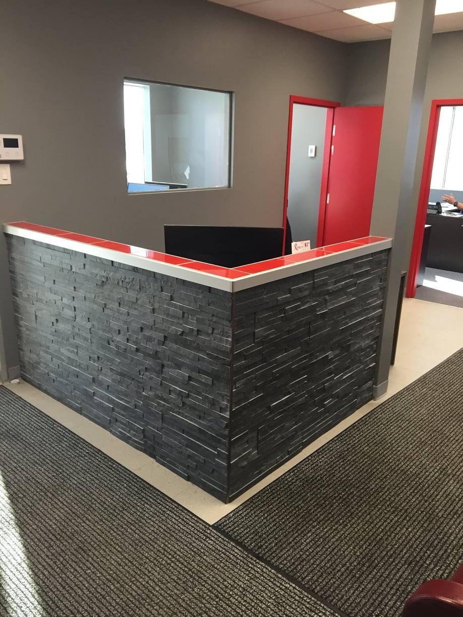 Une pièce avec un mur de briques et une porte rouge.