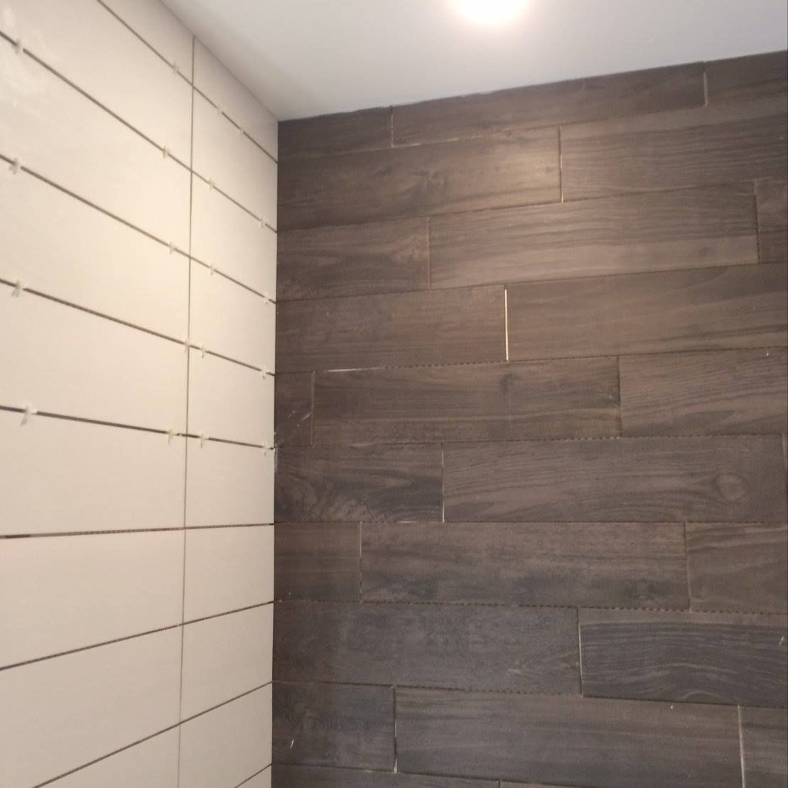 Une salle de bain avec un mur carrelé qui ressemble à du bois