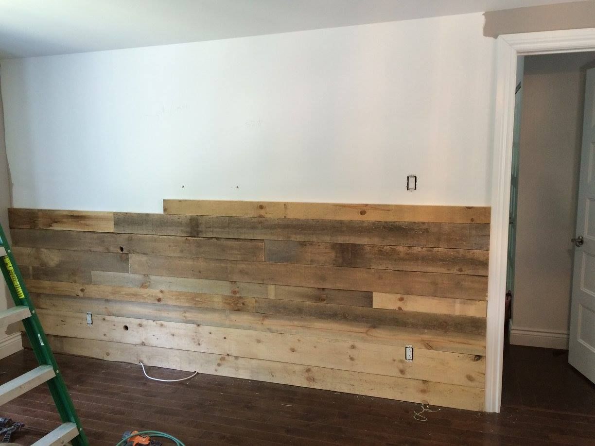 Une pièce avec un mur en bois et une échelle.