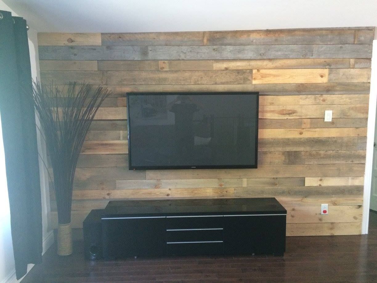 Un salon avec un mur en bois et une télévision à écran plat