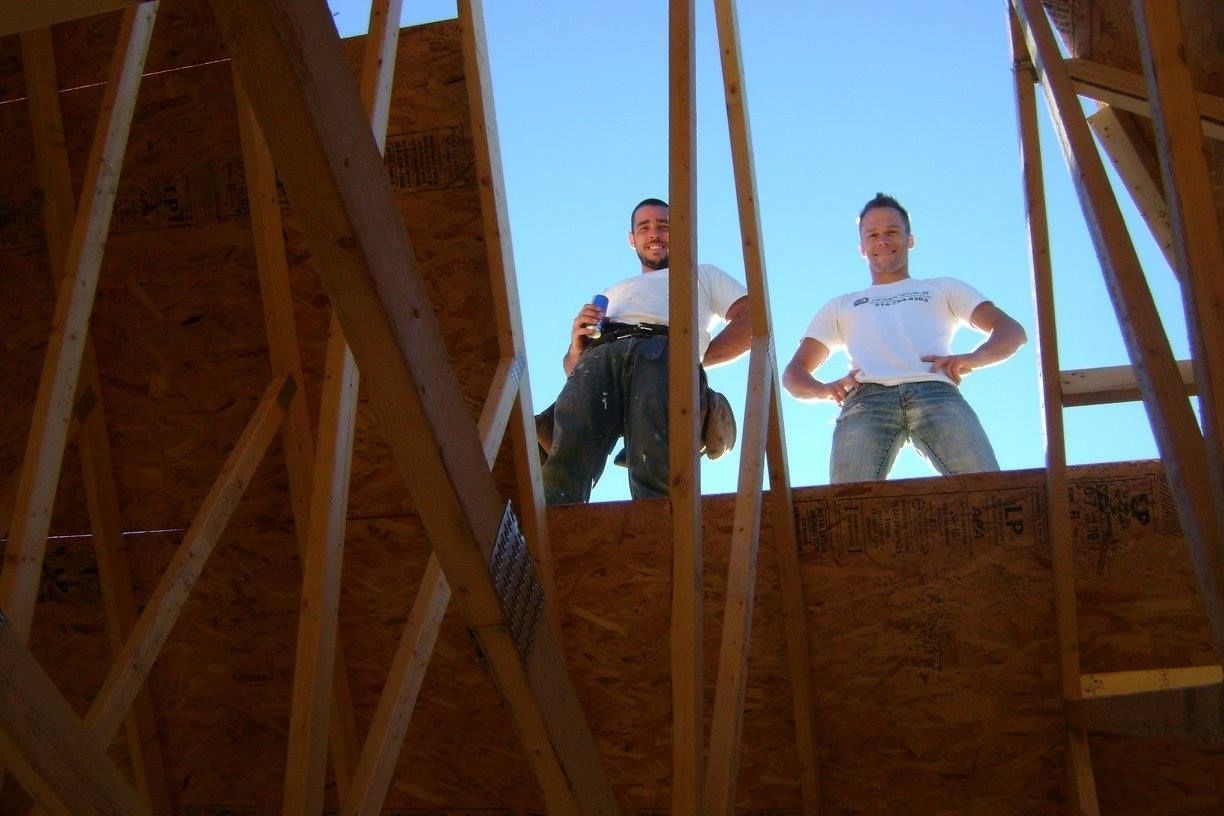 Deux hommes se tiennent debout au sommet d'une structure en bois.