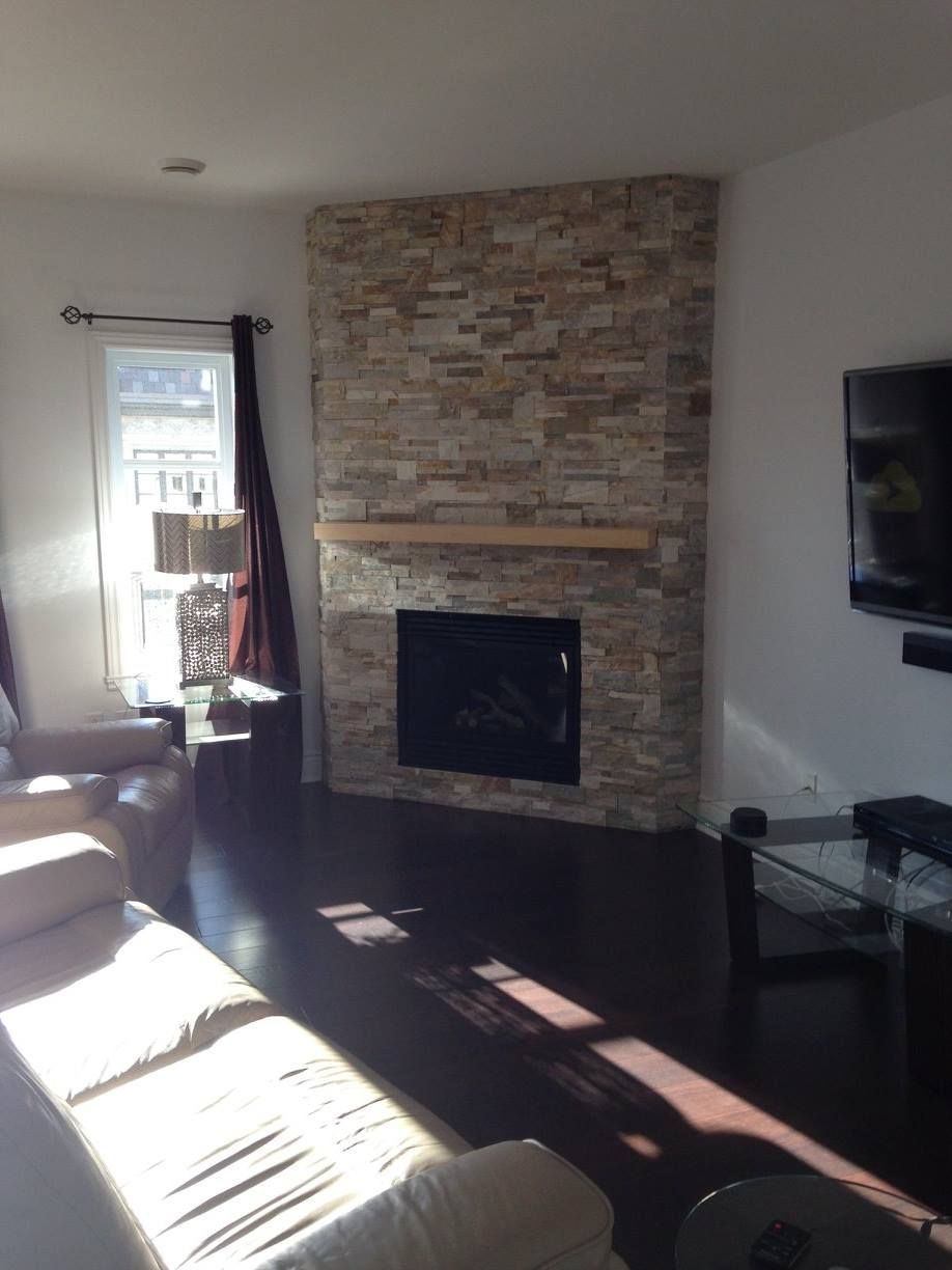 Un salon avec une cheminée en pierre et une télévision à écran plat