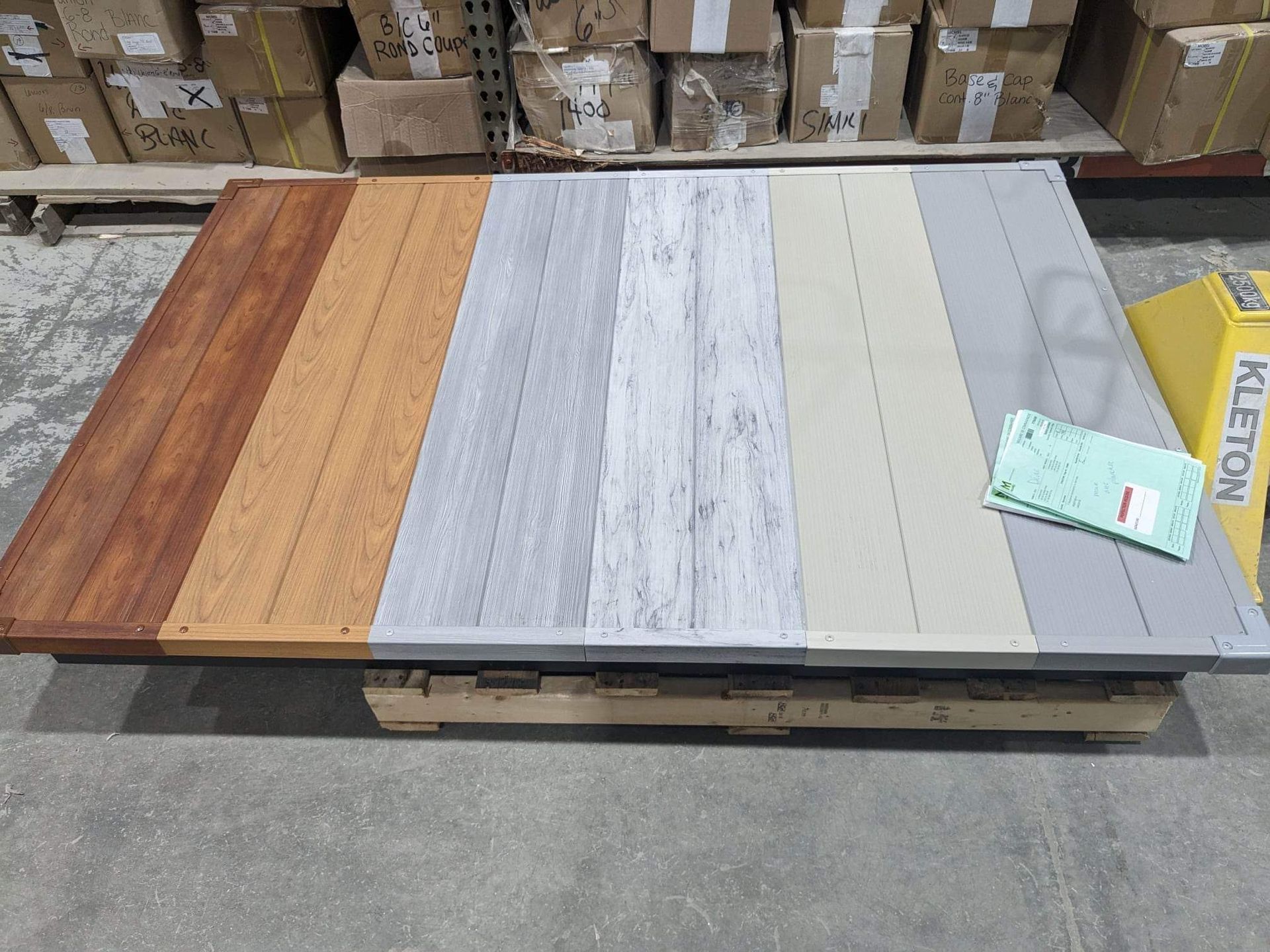 Une table en bois avec différents types de bois dessus dans un entrepôt.