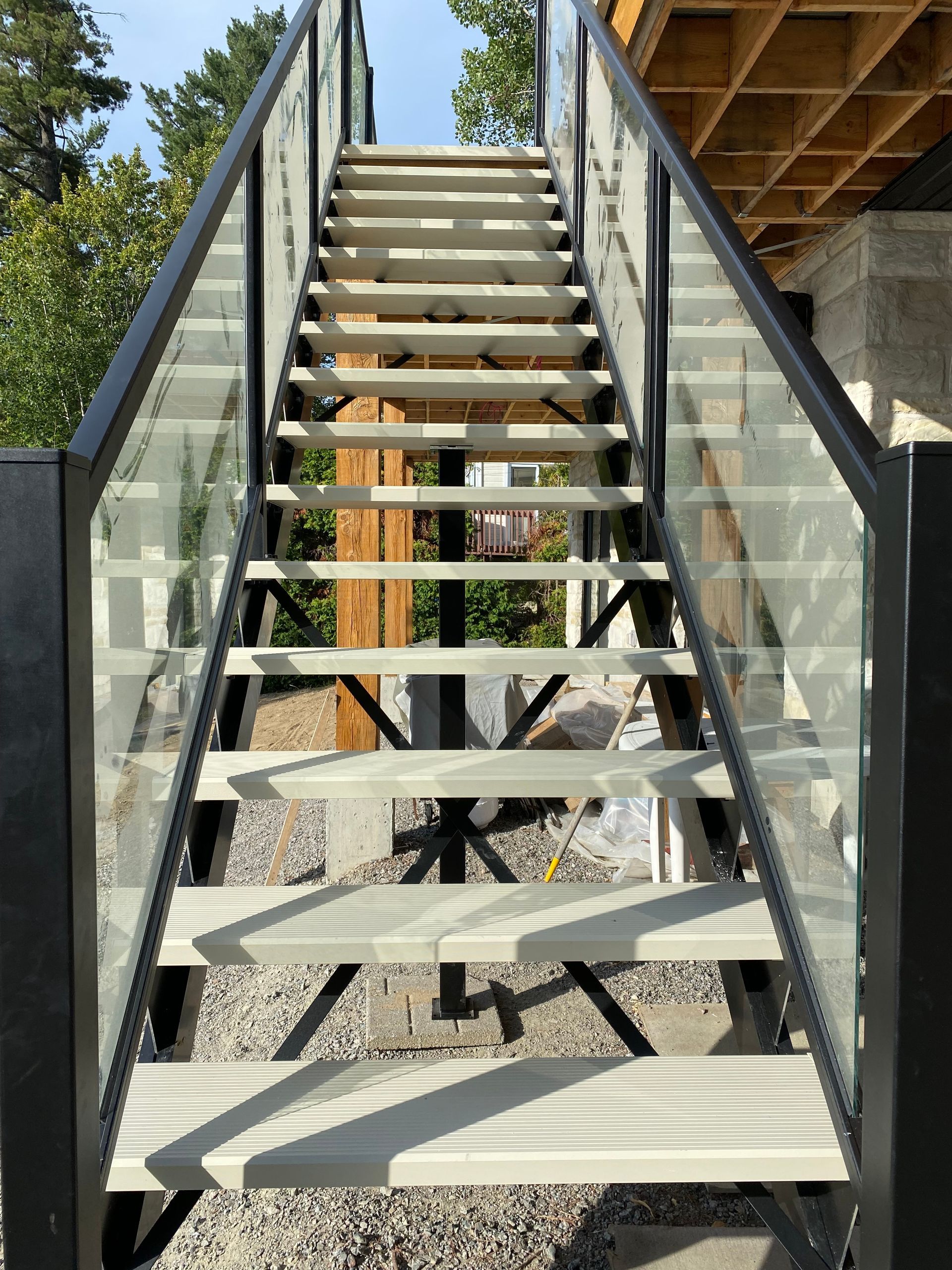 Un ensemble d'escaliers avec une rampe en verre menant à une terrasse.